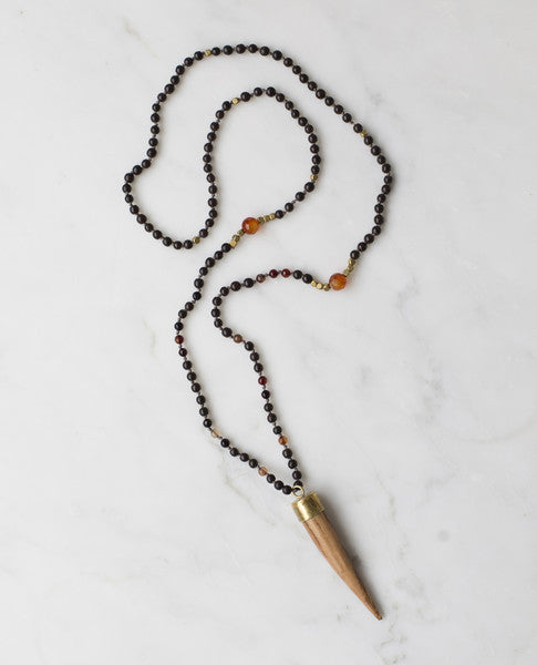 Wooden horn pendant with dark brown beading and carnelian centre stone