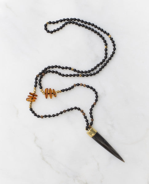 Ethically sourced horn pendant necklace with details of amber